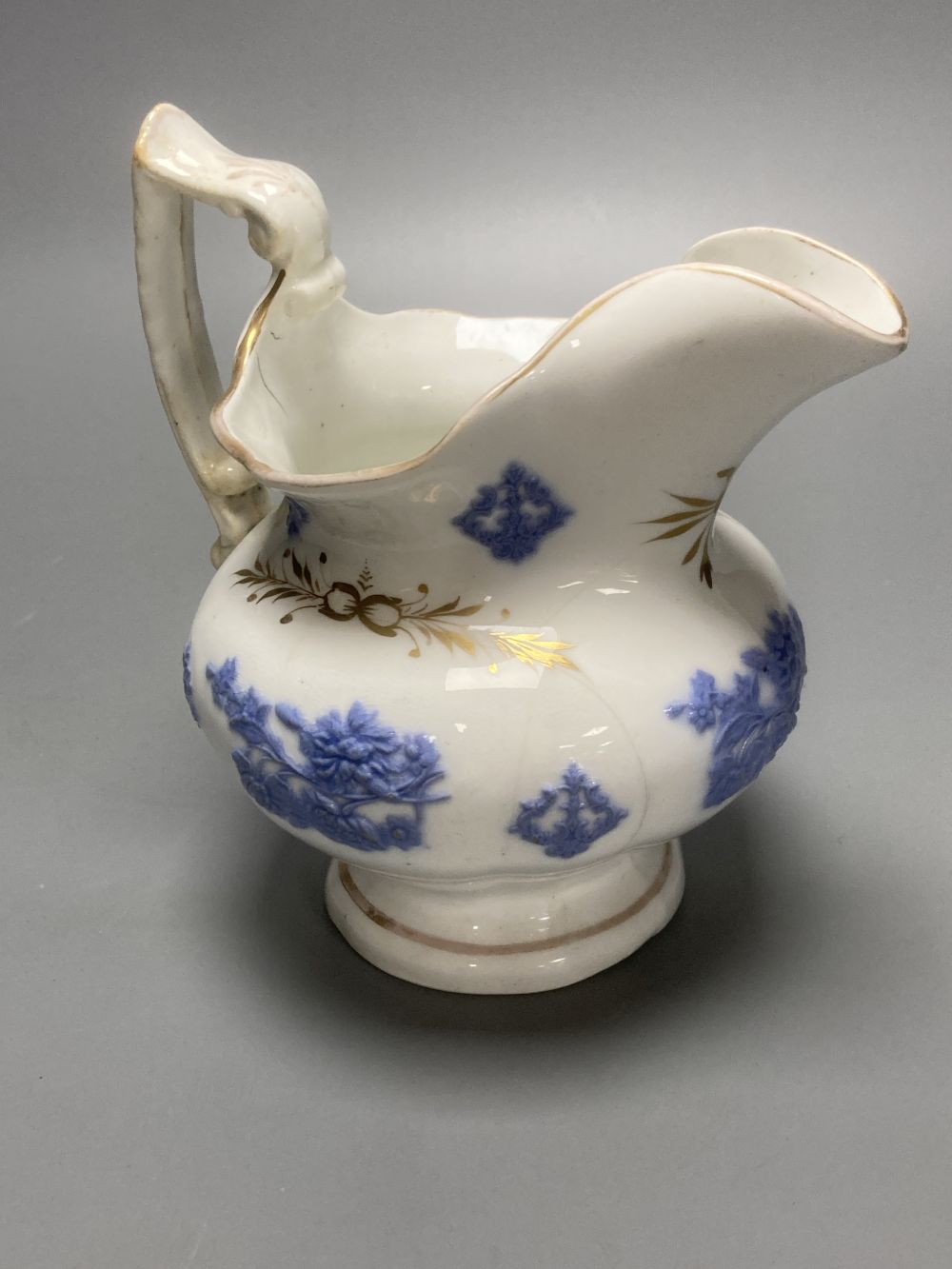 Four early 19th century Staffordshire jugs, each with lilac coloured floral applied panels, one dated 1826, tallest 22cm